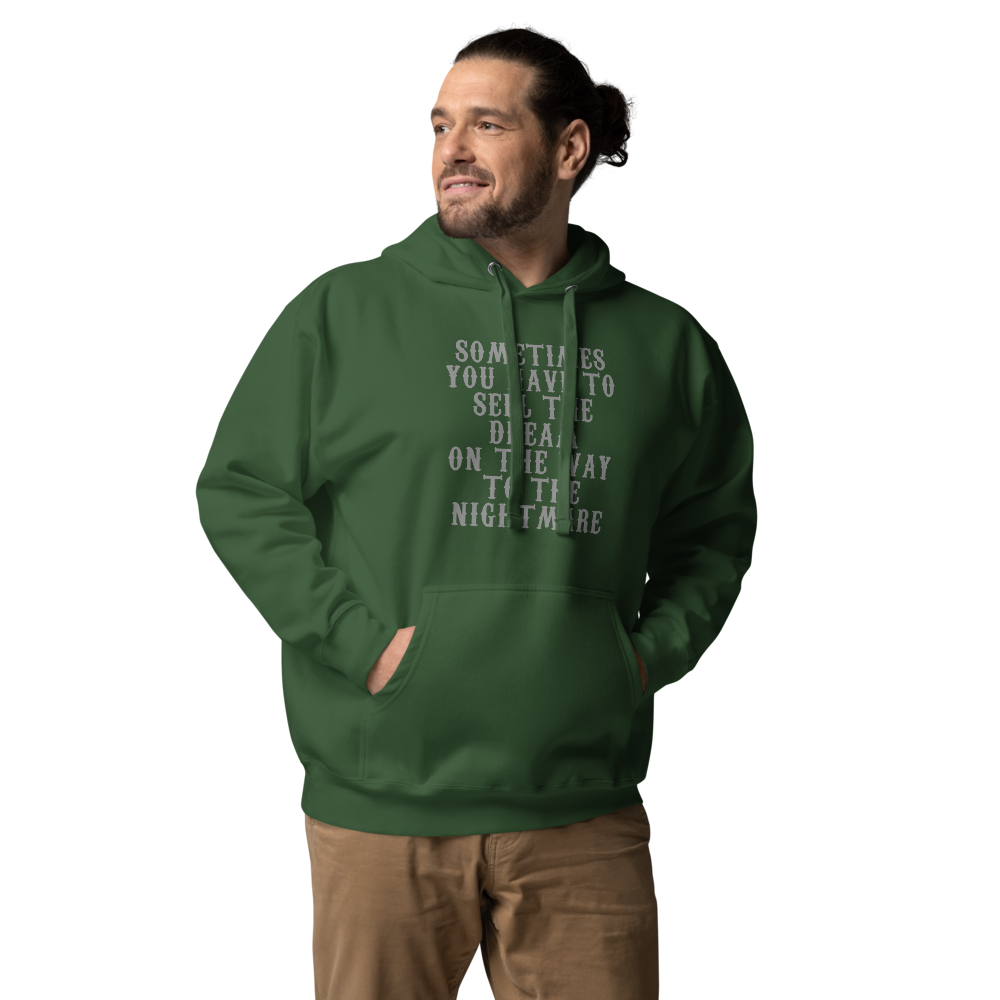 "Sometimes you have to sell the dream on the way to the nightmare" printed on a forest green unisex hoodie worn by a male
