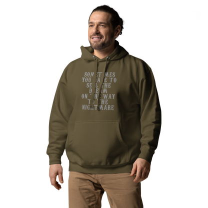 "Sometimes you have to sell the dream on the way to the nightmare" printed on a military green unisex hoodie worn by a male