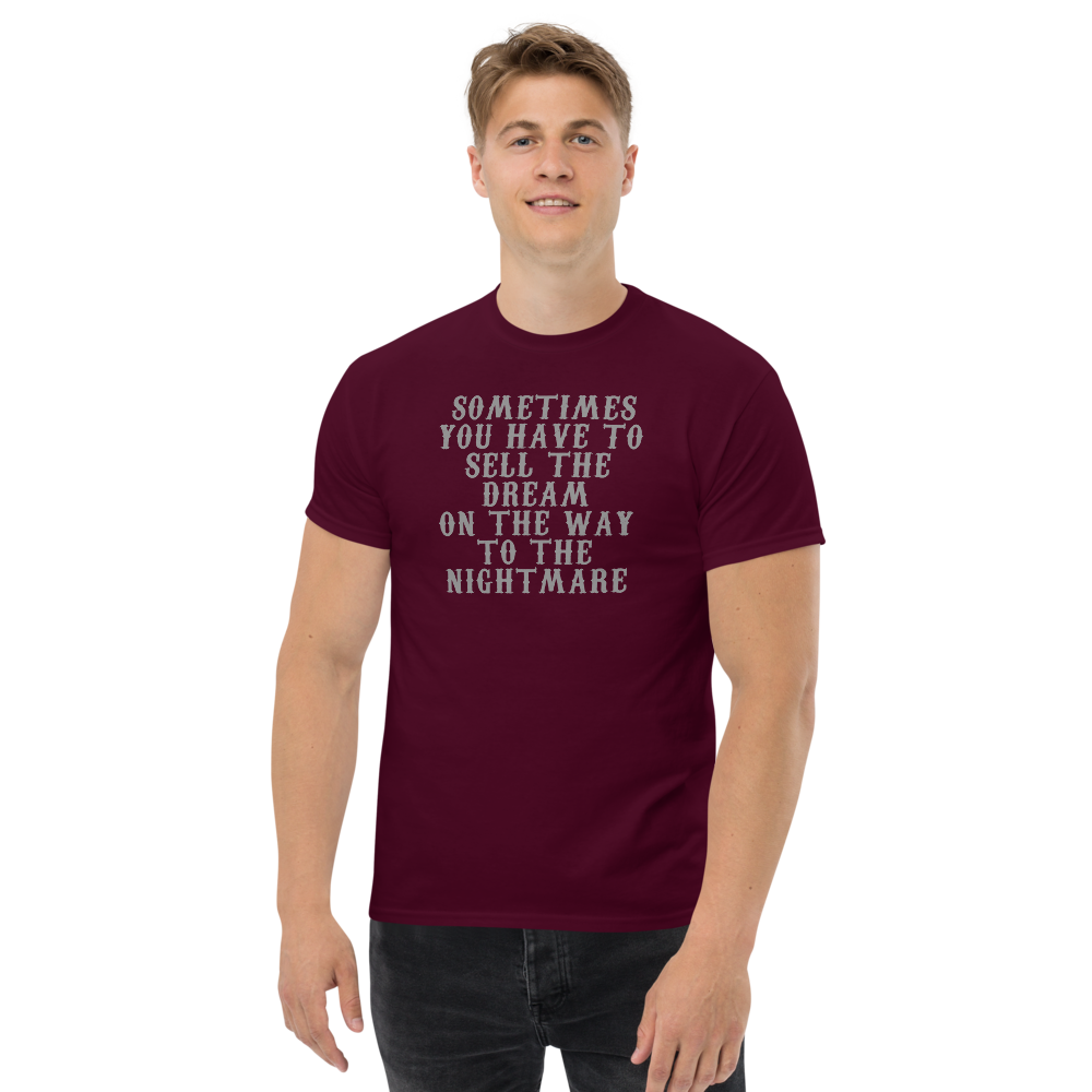 "Sometimes you have to sell the dream on the way to the nightmare" printed on a maroon unisex classic tee worn by a male
