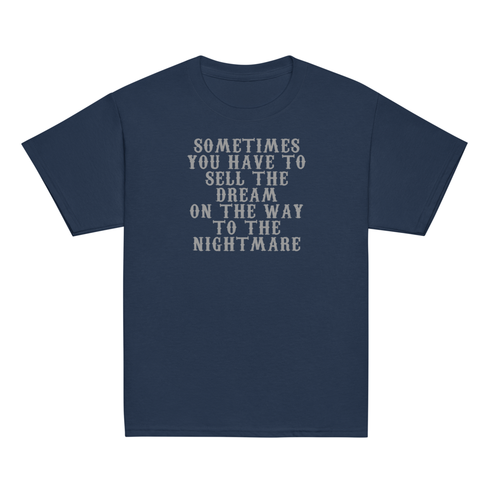 "Sometimes you have to sell the dream on the way to the nightmare" printed on a navy youth classic tee laying on a flat surface