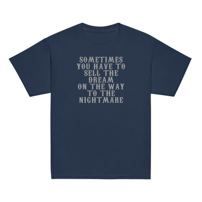 "Sometimes you have to sell the dream on the way to the nightmare" printed on a navy youth classic tee laying on a flat surface