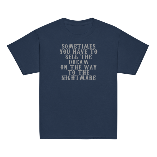 "Sometimes you have to sell the dream on the way to the nightmare" printed on a navy youth classic tee laying on a flat surface