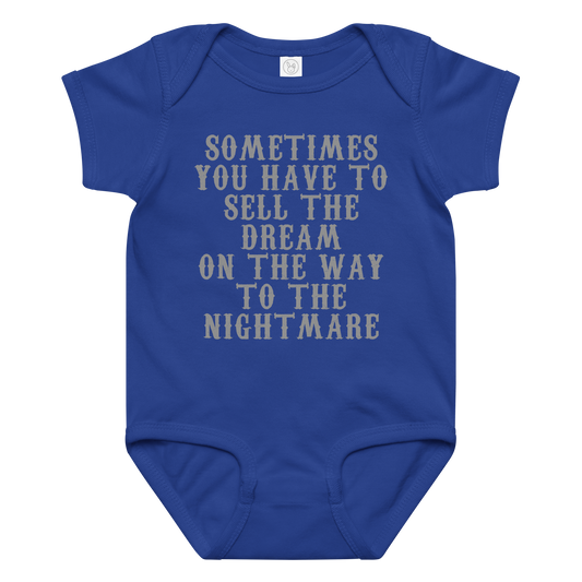 "Sometimes you have to sell the dream on the way to the nightmare" printed on a royal baby jersey bodysuit laying on a flat surface amongst other clothes