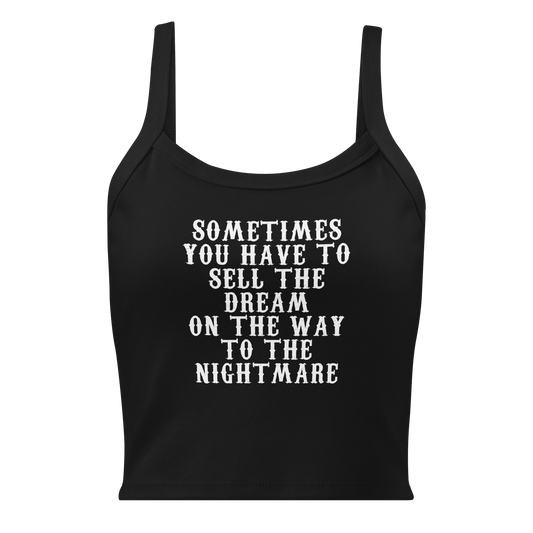 "Sometimes you have to sell the dream on the way to the nightmare" printed on a solid black blend women's micro-rib tanktop laying on a flat surface