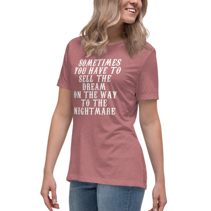 "Sometimes you have to sell the dream on the way to the nightmare" printed on a heather mauve women's relaxed t-shirt worn by a female