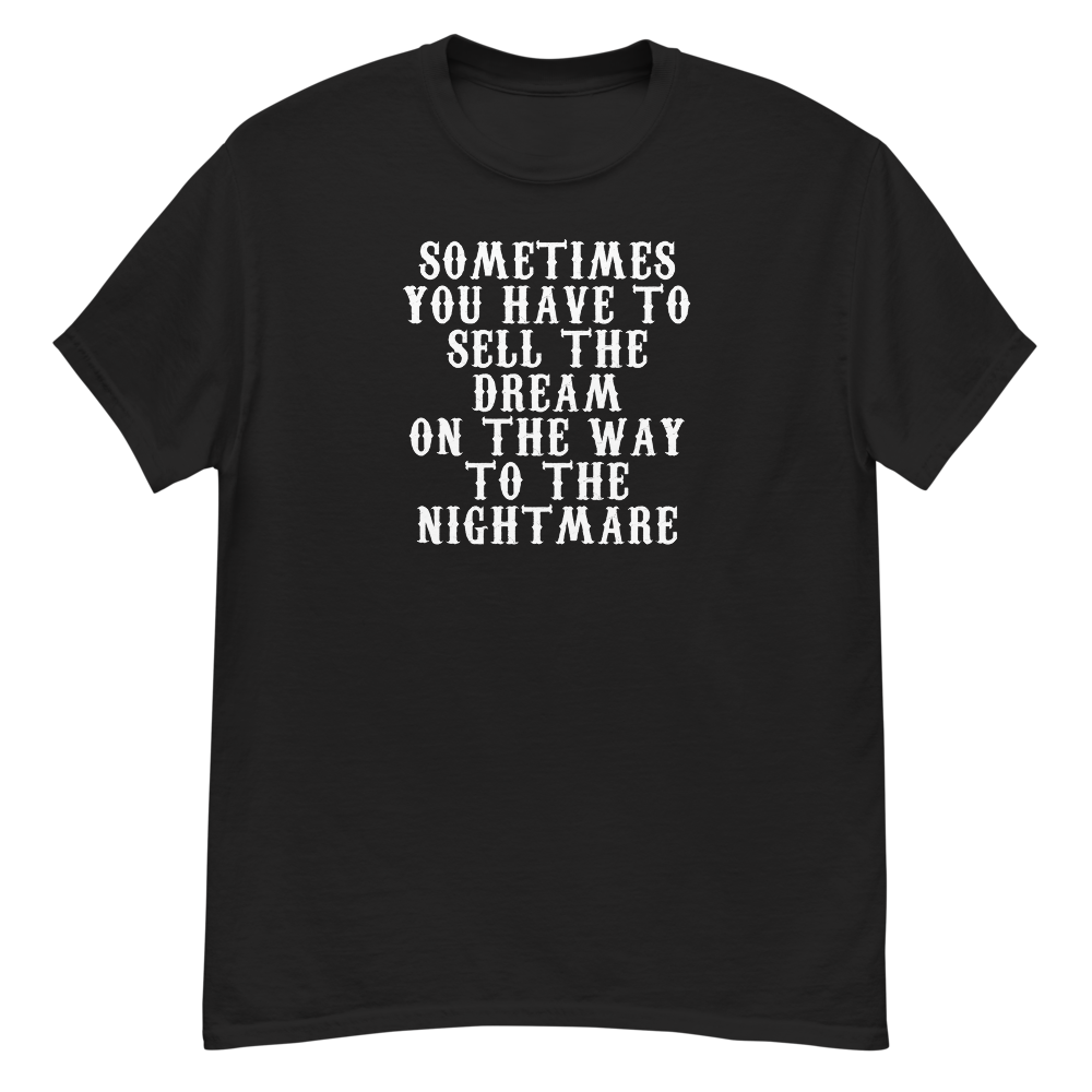 "Sometimes you have to sell the dream on the way to the nightmare" printed on a black unisex classic tee laying on a flat surface