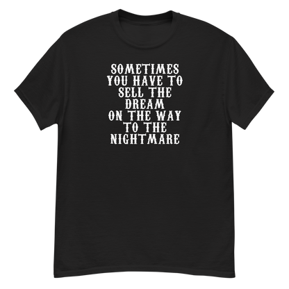 "Sometimes you have to sell the dream on the way to the nightmare" printed on a black unisex classic tee laying on a flat surface