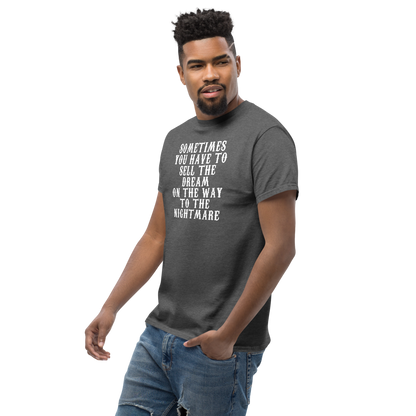 "Sometimes you have to sell the dream on the way to the nightmare" printed on a dark heather unisex classic tee worn by a male