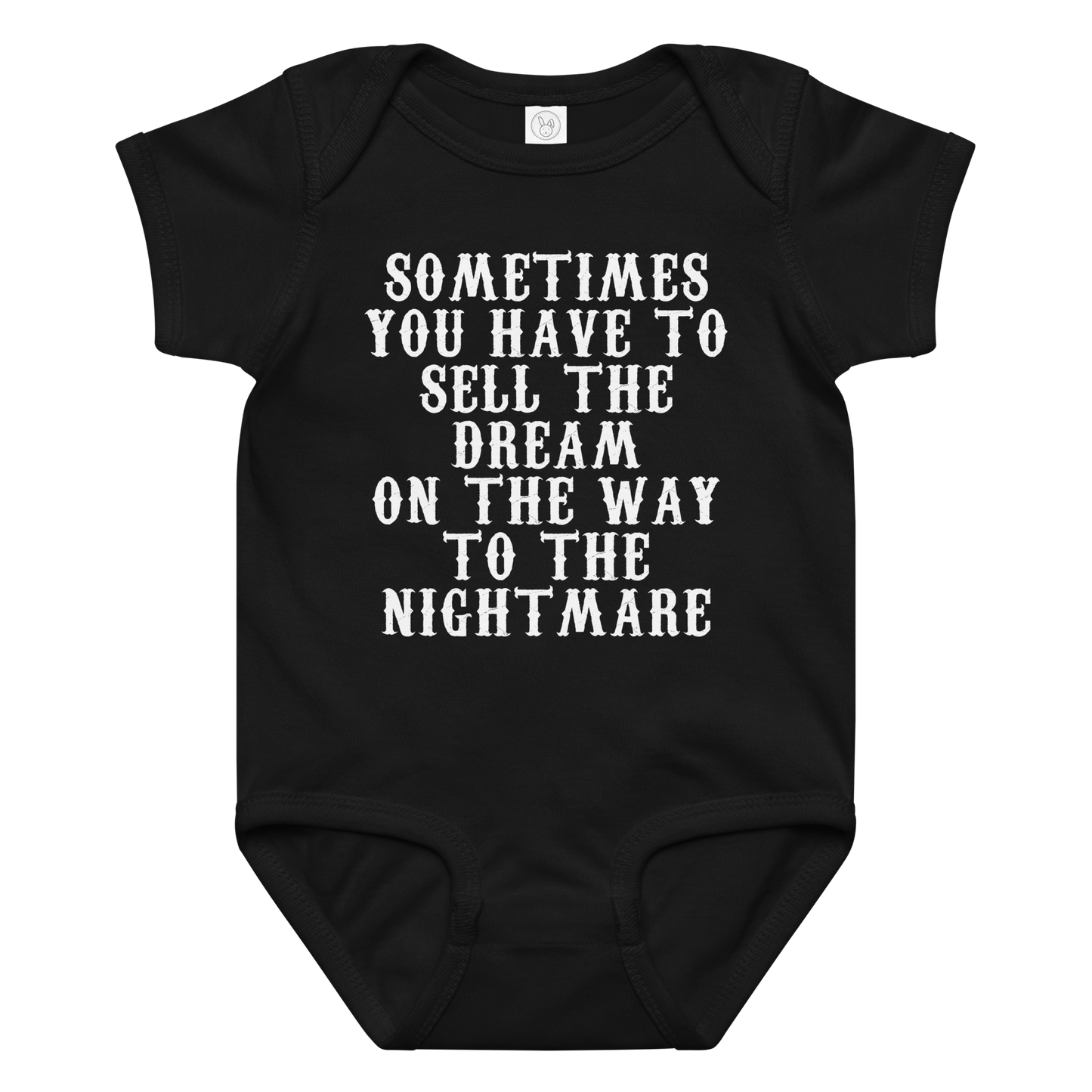 "Sometimes you have to sell the dream on the way to the nightmare" printed on a black baby jersey bodysuit laying on a flat surface amongst other clothes