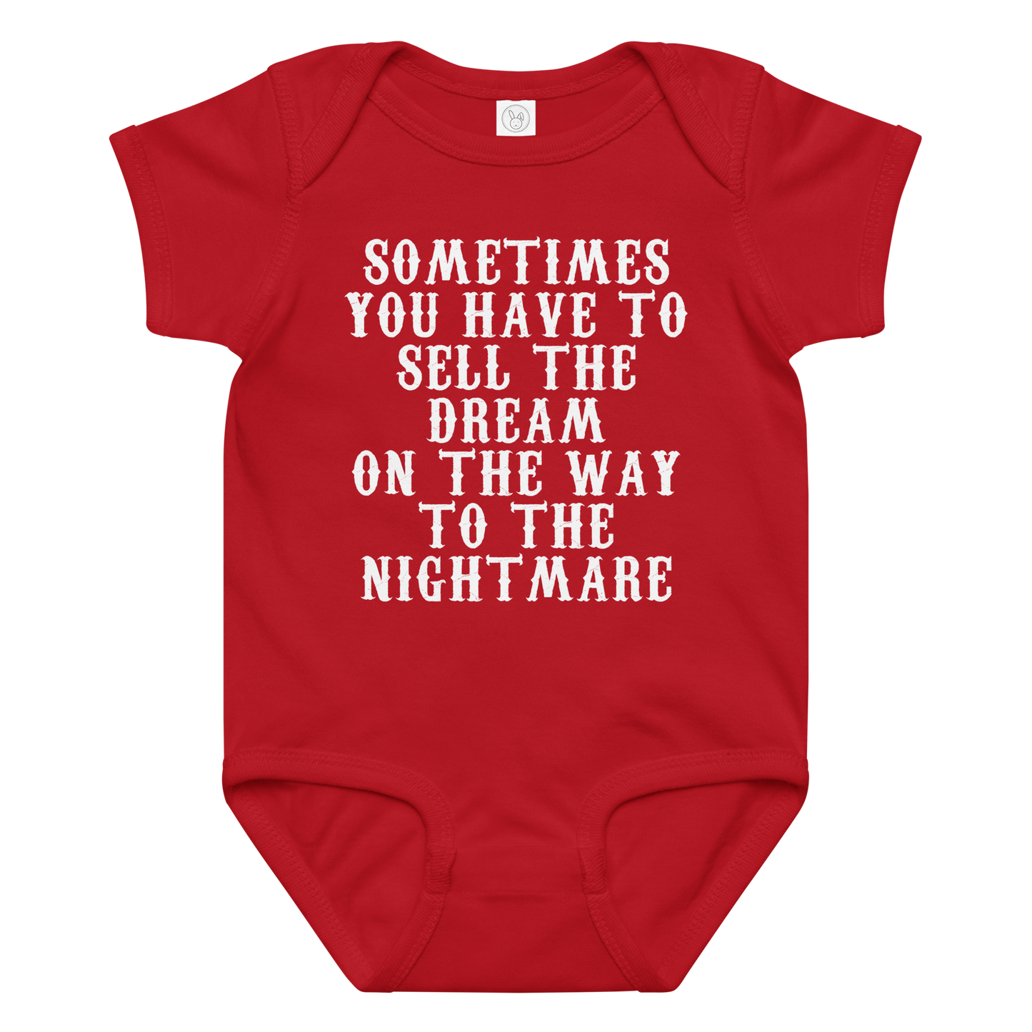 "Sometimes you have to sell the dream on the way to the nightmare" printed on a red baby jersey bodysuit laying on a flat surface amongst other clothes