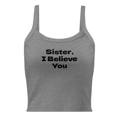 "Sister, I Believe You!" printed on a athletic heather women's micro-rib tanktop laying on a flat surface