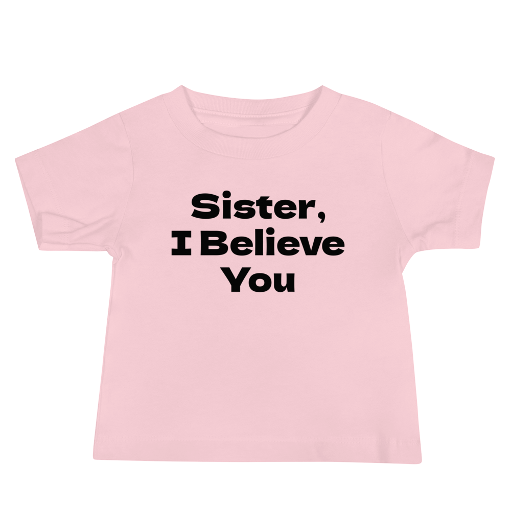 "Sister, I Believe You!" printed on a pink baby jersey short sleeve tee laying on a flat surface