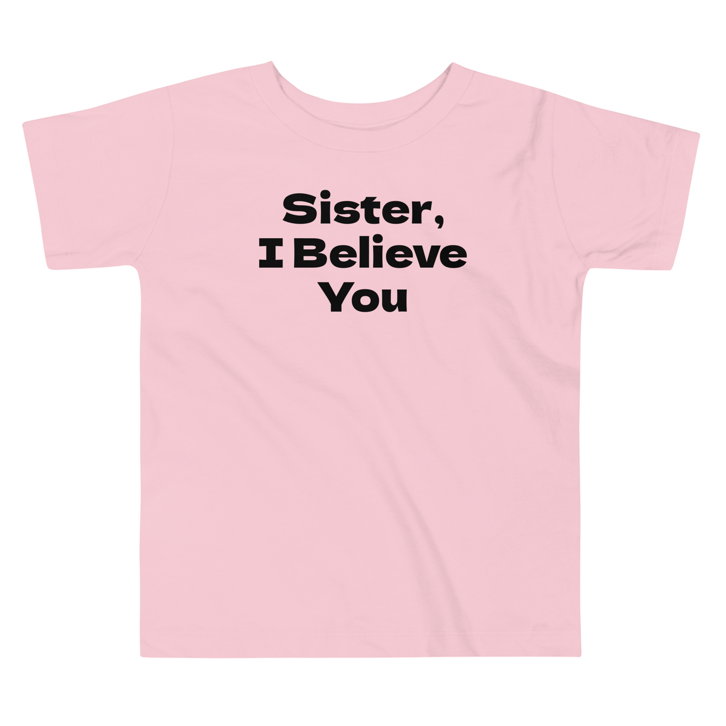 "Sister, I Believe You!" printed on a pink toddler short sleeve tee laying on a flat surface