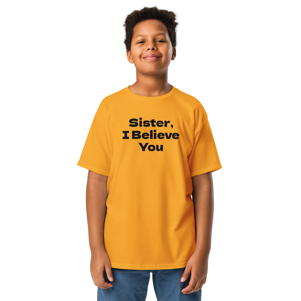 "Sister, I Believe You!" printed on a gold youth classic tee worn by a male