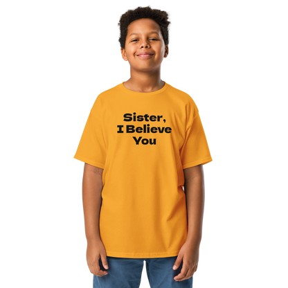 "Sister, I Believe You!" printed on a gold youth classic tee worn by a male
