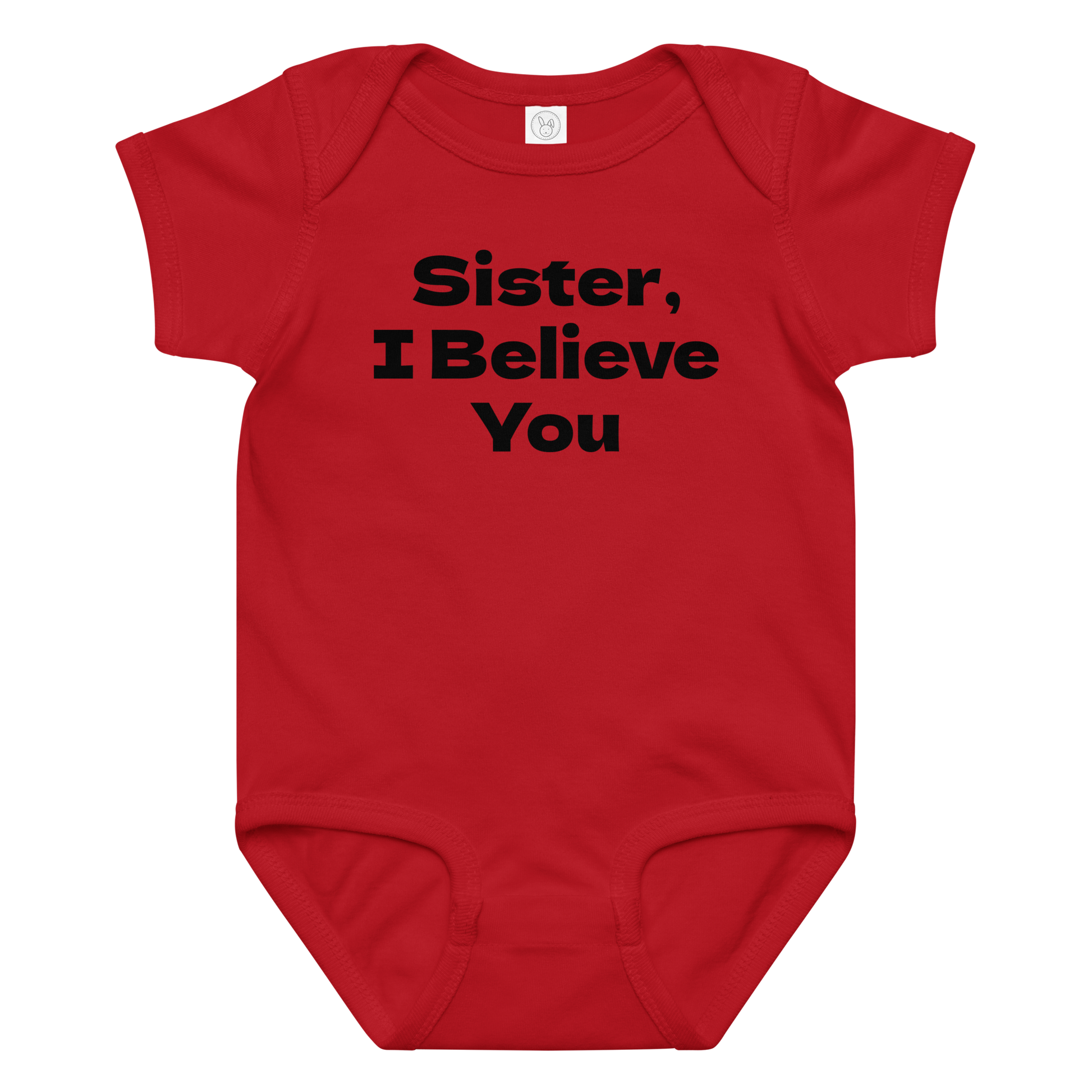 "Sister, I Believe You!" printed on a red baby jersey bodysuit laying on a flat surface amongst other clothes