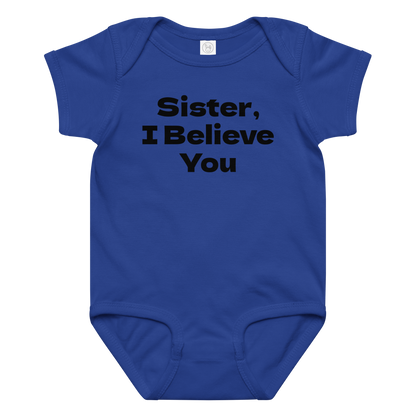 "Sister, I Believe You!" printed on a royal baby jersey bodysuit laying on a flat surface amongst other clothes