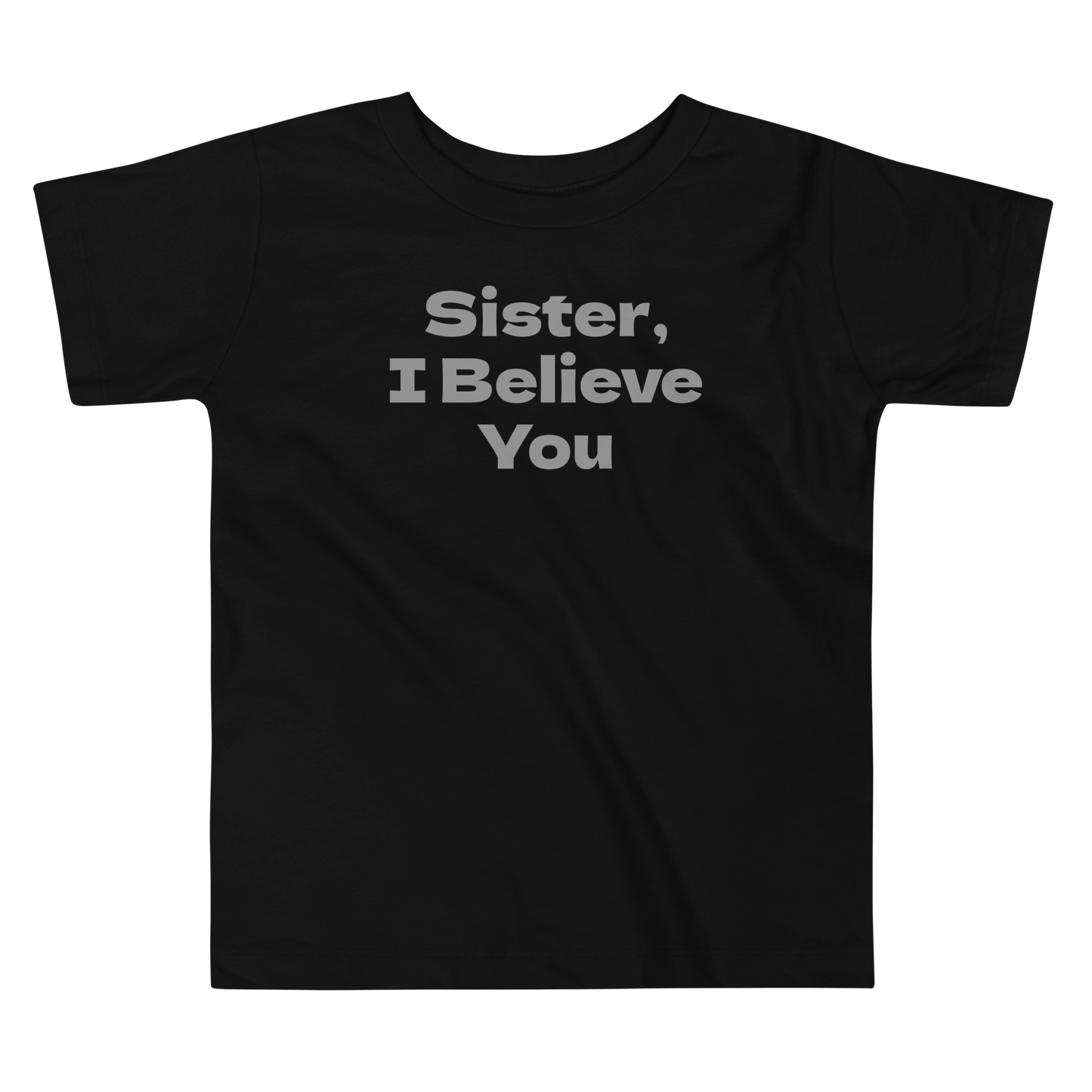 "Sister, I Believe You!" printed on a black toddler short sleeve tee laying on a flat surface