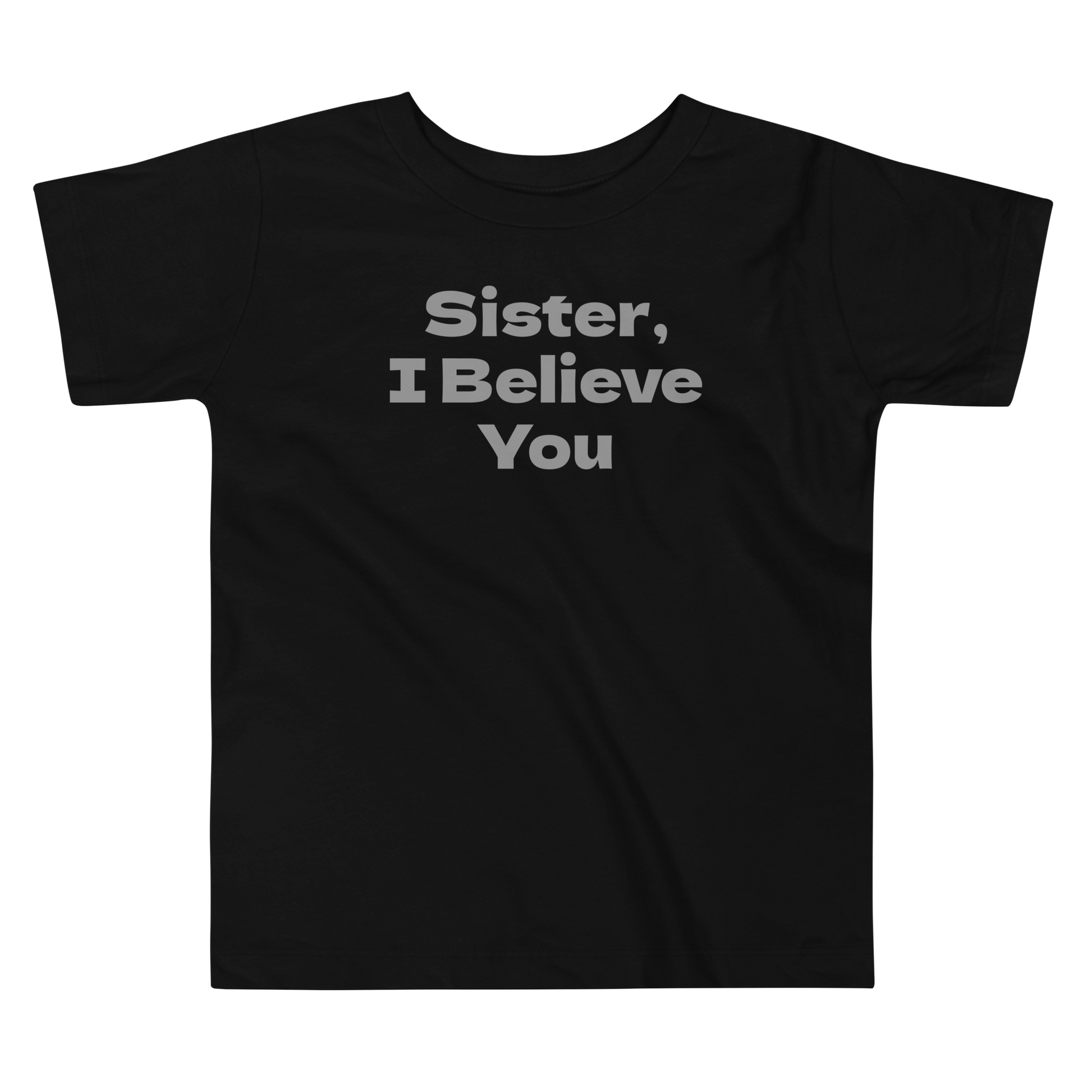 "Sister, I Believe You!" printed on a black toddler short sleeve tee laying on a flat surface