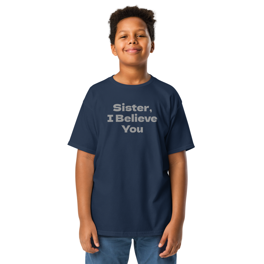 "Sister, I Believe You!" printed on a navy youth classic tee worn by a male