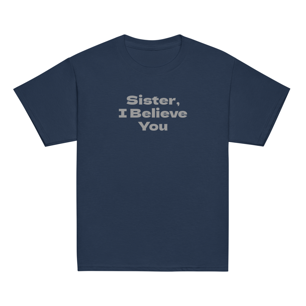 "Sister, I Believe You!" printed on a navy youth classic tee laying on a flat surface