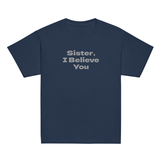 "Sister, I Believe You!" printed on a navy youth classic tee laying on a flat surface