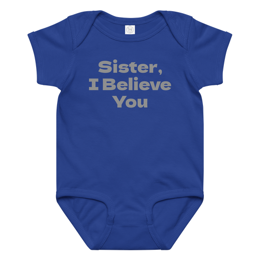 "Sister, I Believe You!" printed on a royal baby jersey bodysuit laying on a flat surface amongst other clothes