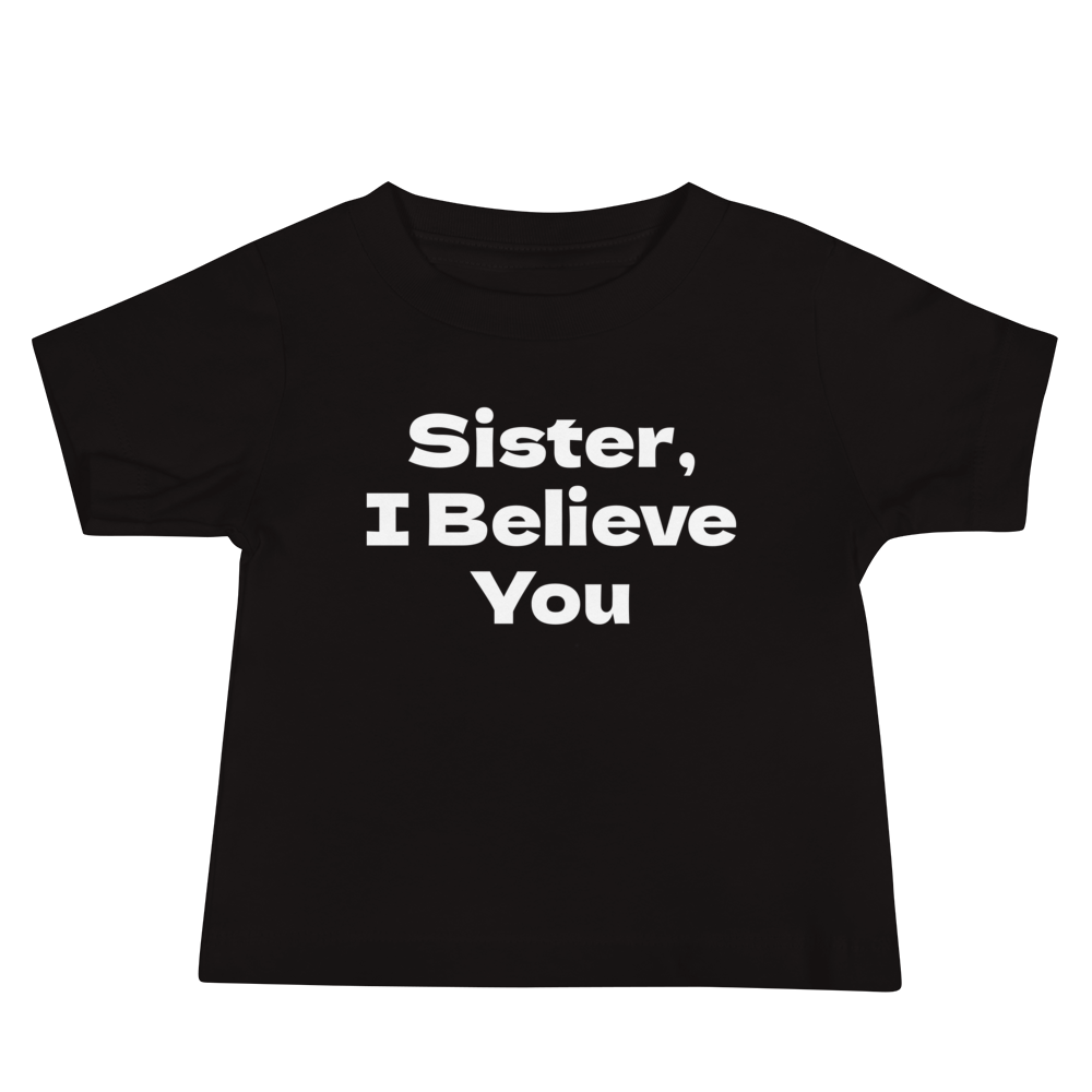 "Sister, I Believe You!" printed on a black baby jersey short sleeve tee laying on a flat surface