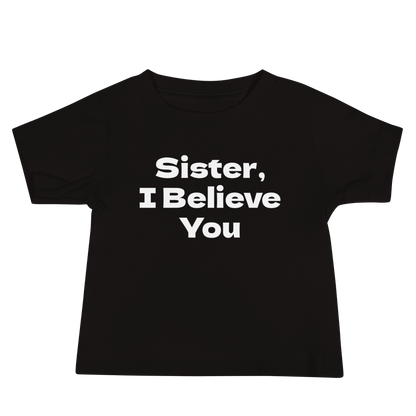 "Sister, I Believe You!" printed on a black baby jersey short sleeve tee laying on a flat surface