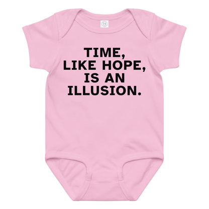 "Time, like hope, is an illusion" printed on a pink baby jersey bodysuit laying on a flat surface amongst other clothes