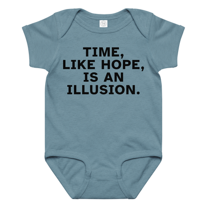 "Time, like hope, is an illusion" printed on a vintage indigo baby jersey bodysuit laying on a flat surface amongst other clothes
