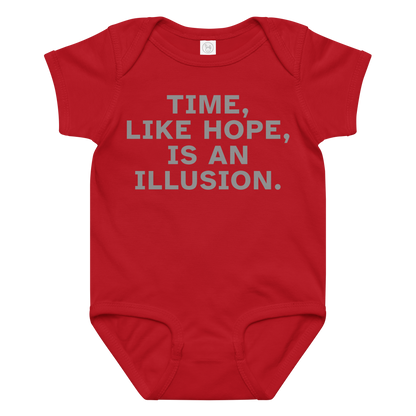 "Time, like hope, is an illusion" printed on a red baby jersey bodysuit laying on a flat surface amongst other clothes