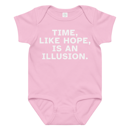 "Time, like hope, is an illusion" printed on a pink baby jersey bodysuit laying on a flat surface amongst other clothes