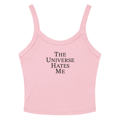 "The Universe Hates Me" printed on a solid pink blend women's micro-rib tanktop laying on a flat surface amongst sunglasses and shorts