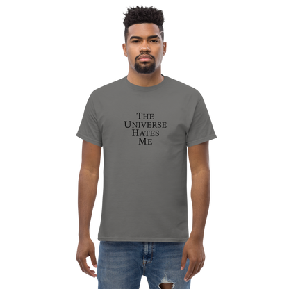 "The Universe Hates Me" printed on a charcoal unisex classic tee worn by a male