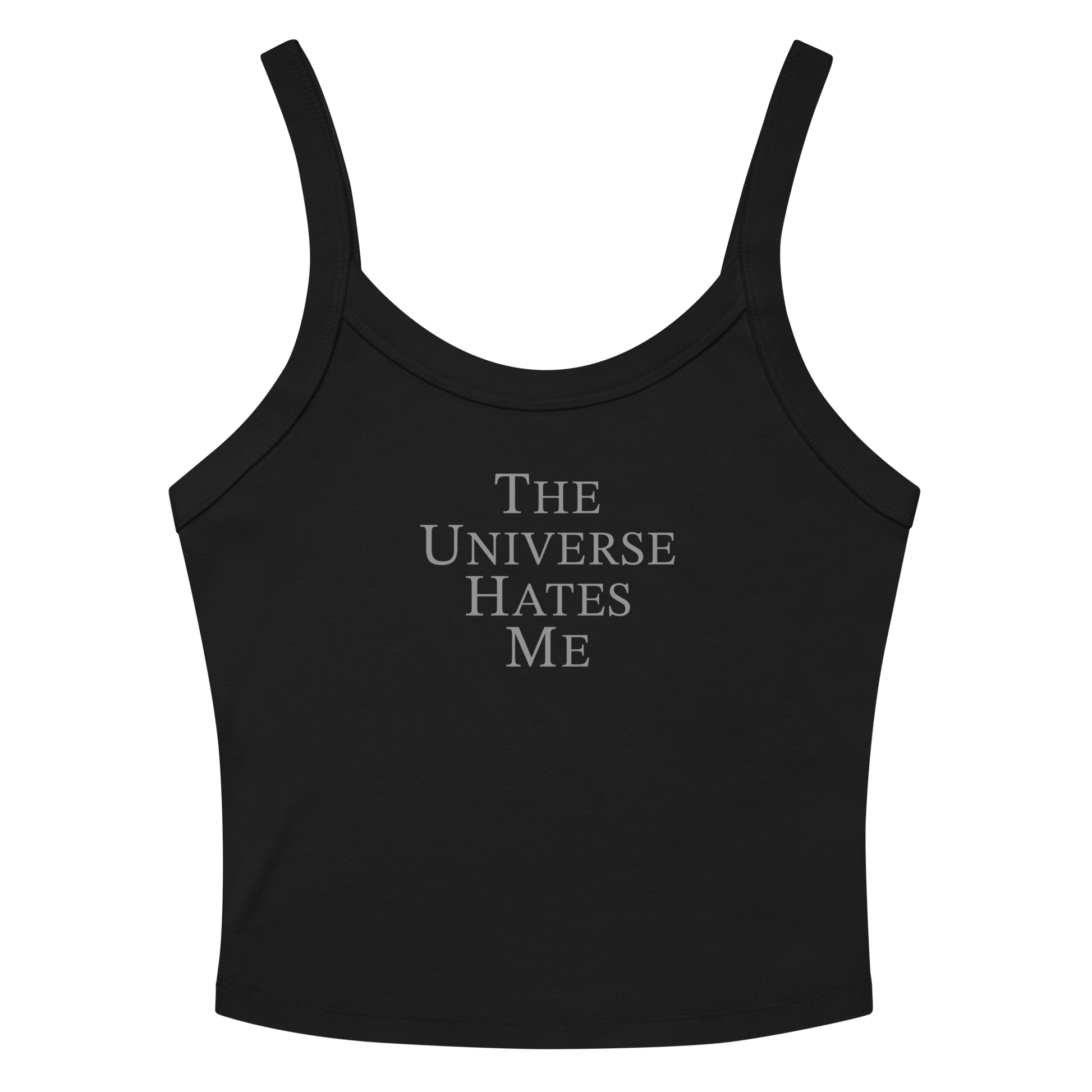 "The Universe Hates Me" printed on a solid black blend women's micro-rib tanktop laying on a flat surface amongst sunglasses and shorts