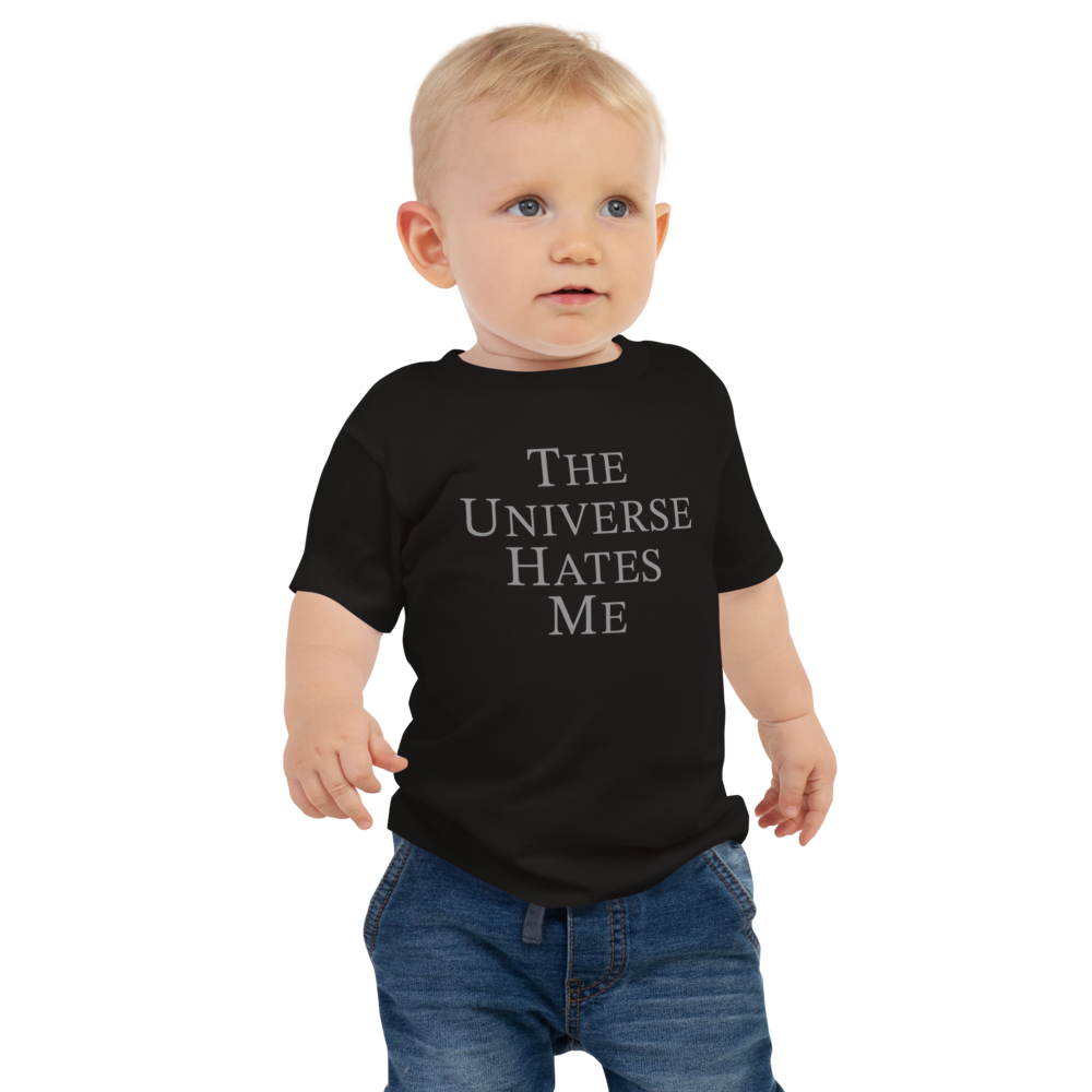 "The Universe Hates Me" printed on a black baby jersey short sleeve tee worn by a male