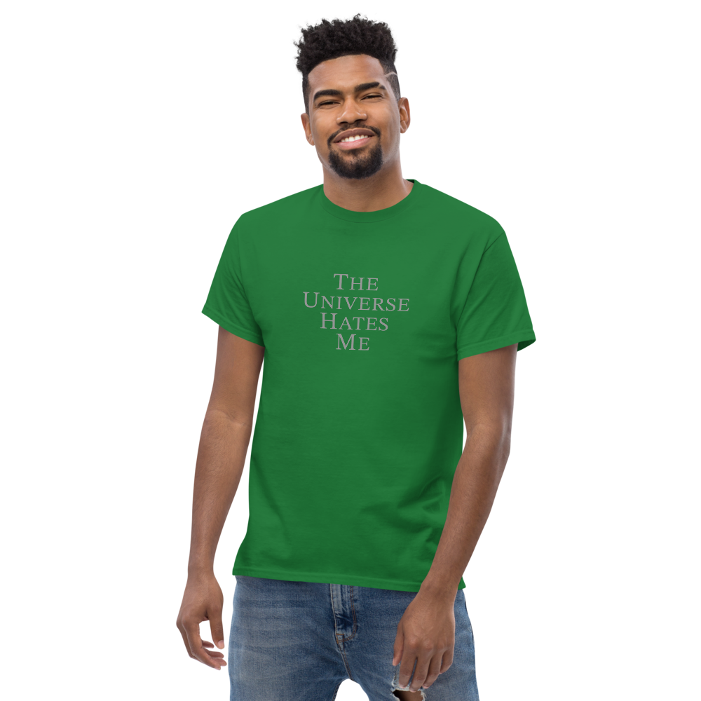 "The Universe Hates Me" printed on a turf green unisex classic tee worn by a male