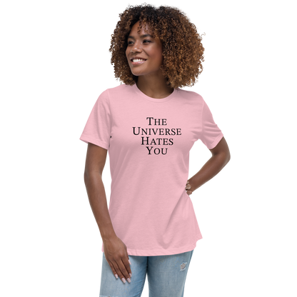 "The Universe Hates You" printed on a pink women's relaxed t-shirt worn by a female