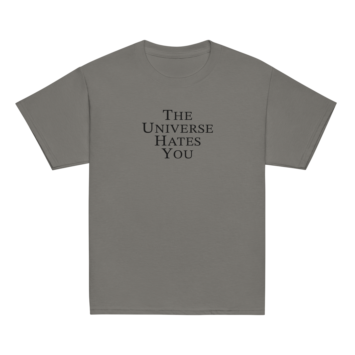 "The Universe Hates You" printed on a charcoal youth classic tee laying on a flat surface