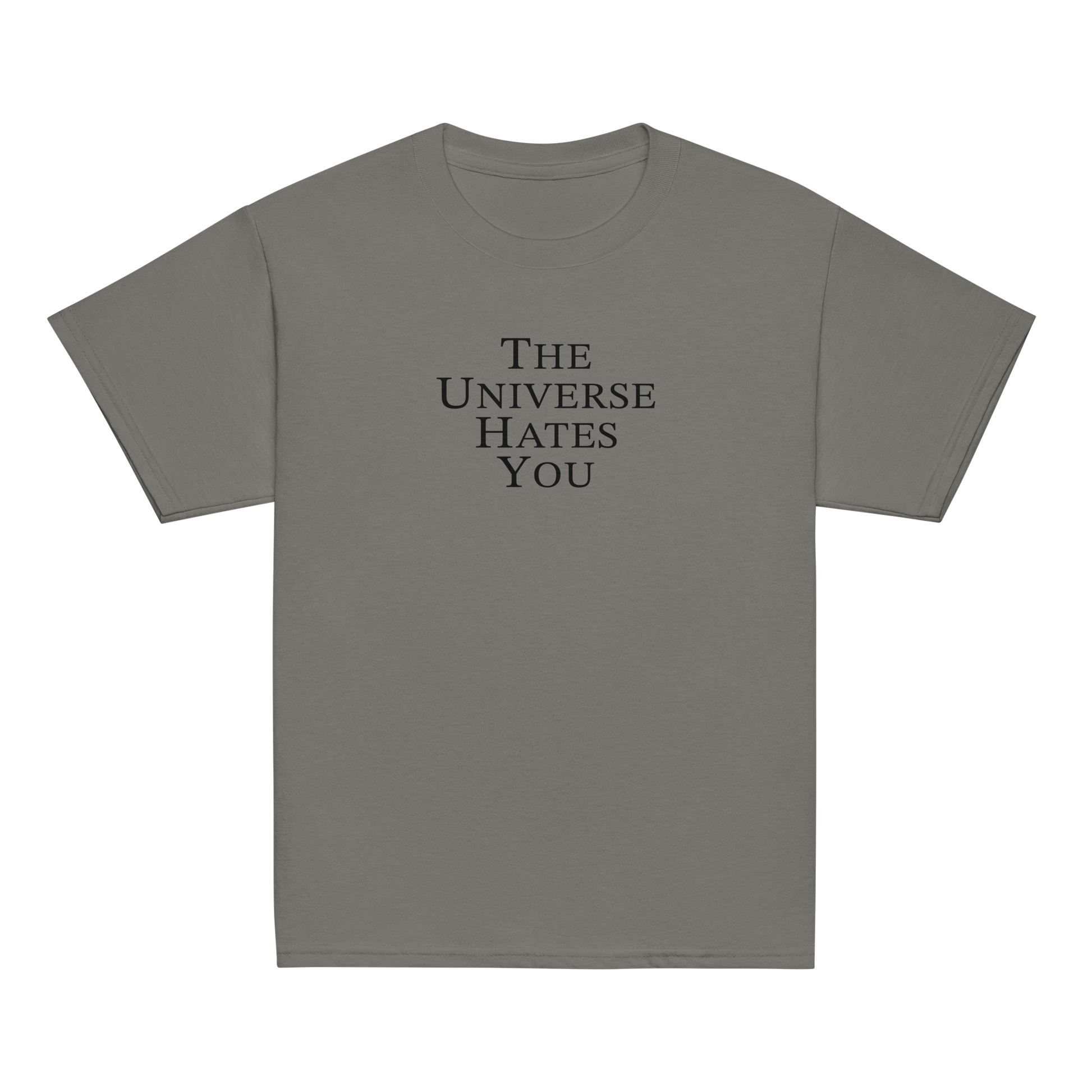 "The Universe Hates You" printed on a charcoal youth classic tee laying on a flat surface