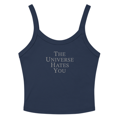 "The Universe Hates You" printed on a solid navy blend women's micro-rib tanktop laying on a flat surface amongst sunglasses and shorts
