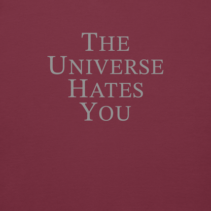 "The Universe Hates You" printed on a maroon background