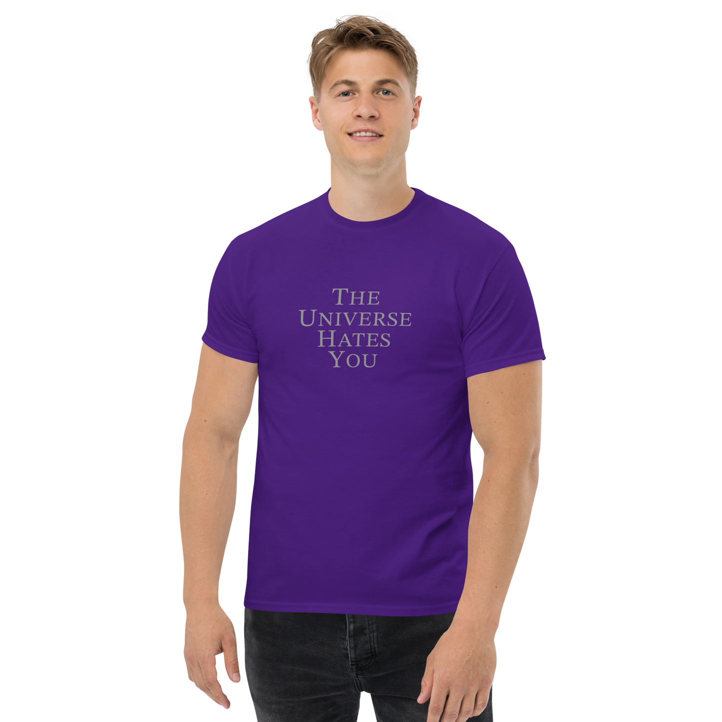 "The Universe Hates You" printed on a purple unisex classic tee worn by a male