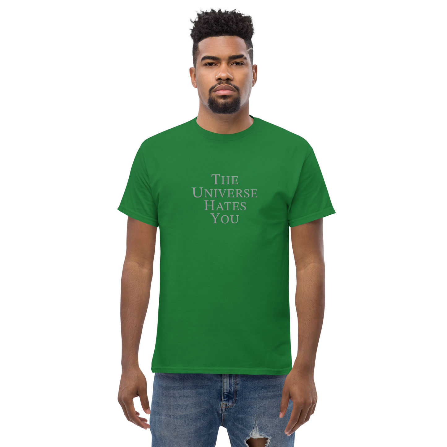 "The Universe Hates You" printed on a turf green unisex classic tee worn by a male
