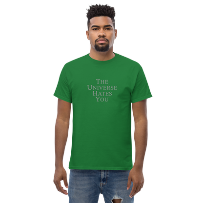 "The Universe Hates You" printed on a turf green unisex classic tee worn by a male