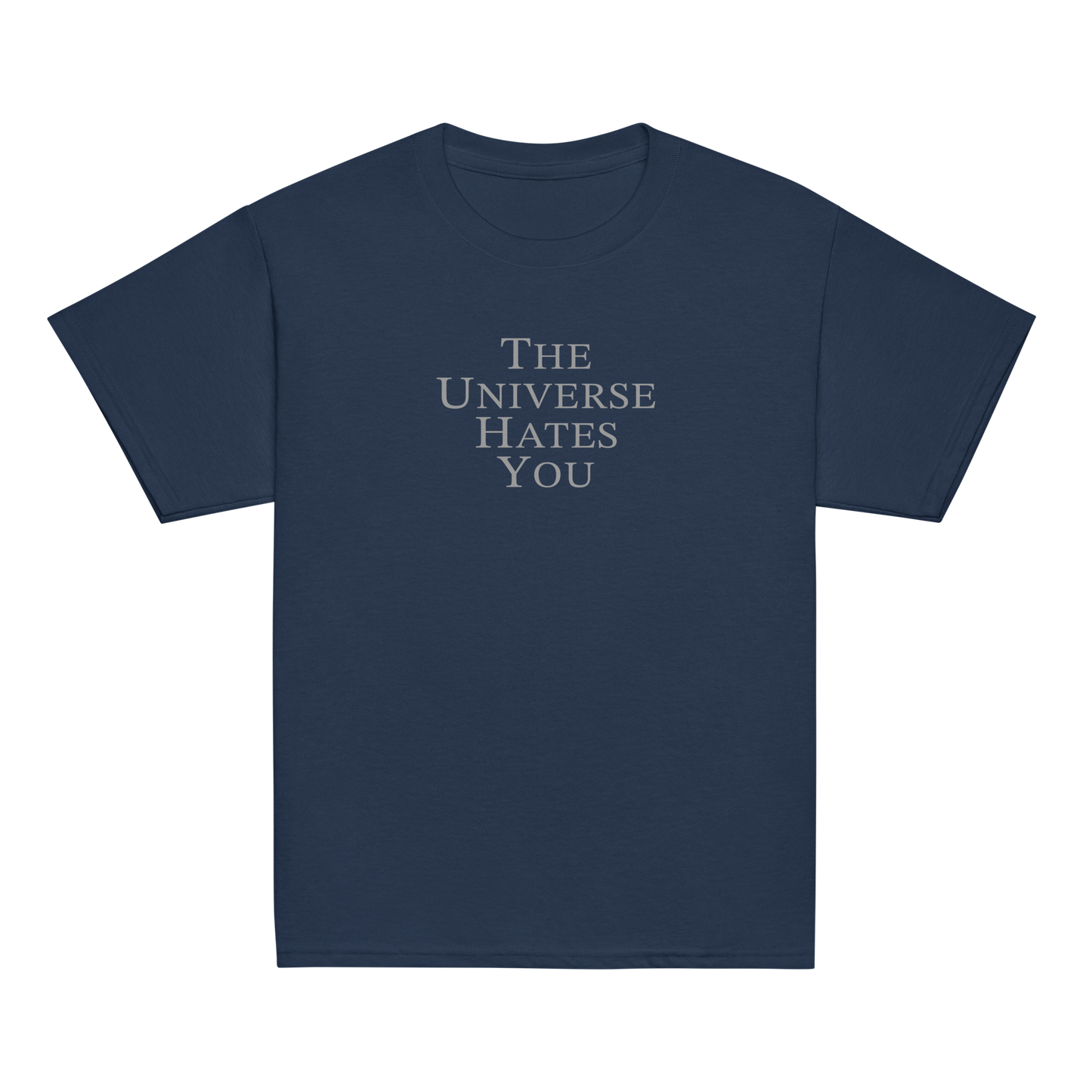 "The Universe Hates You" printed on a navy youth classic tee laying on a flat surface
