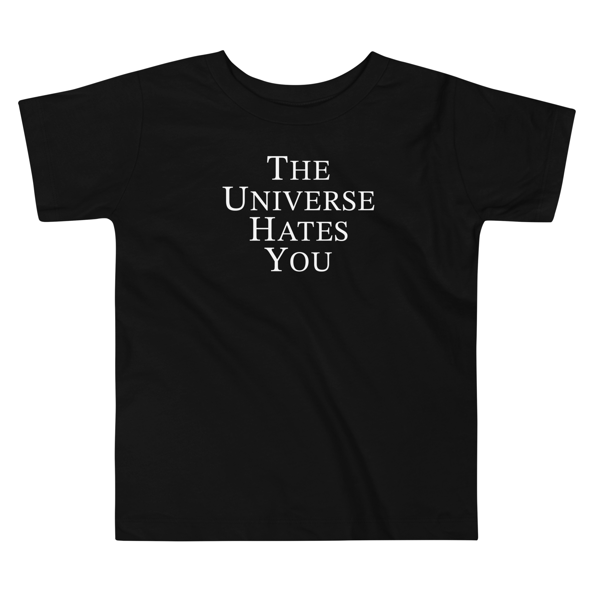 "The Universe Hates You" printed on a black toddler short sleeve tee laying on a flat surface