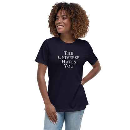 "The Universe Hates You" printed on a navy women's relaxed t-shirt worn by a female