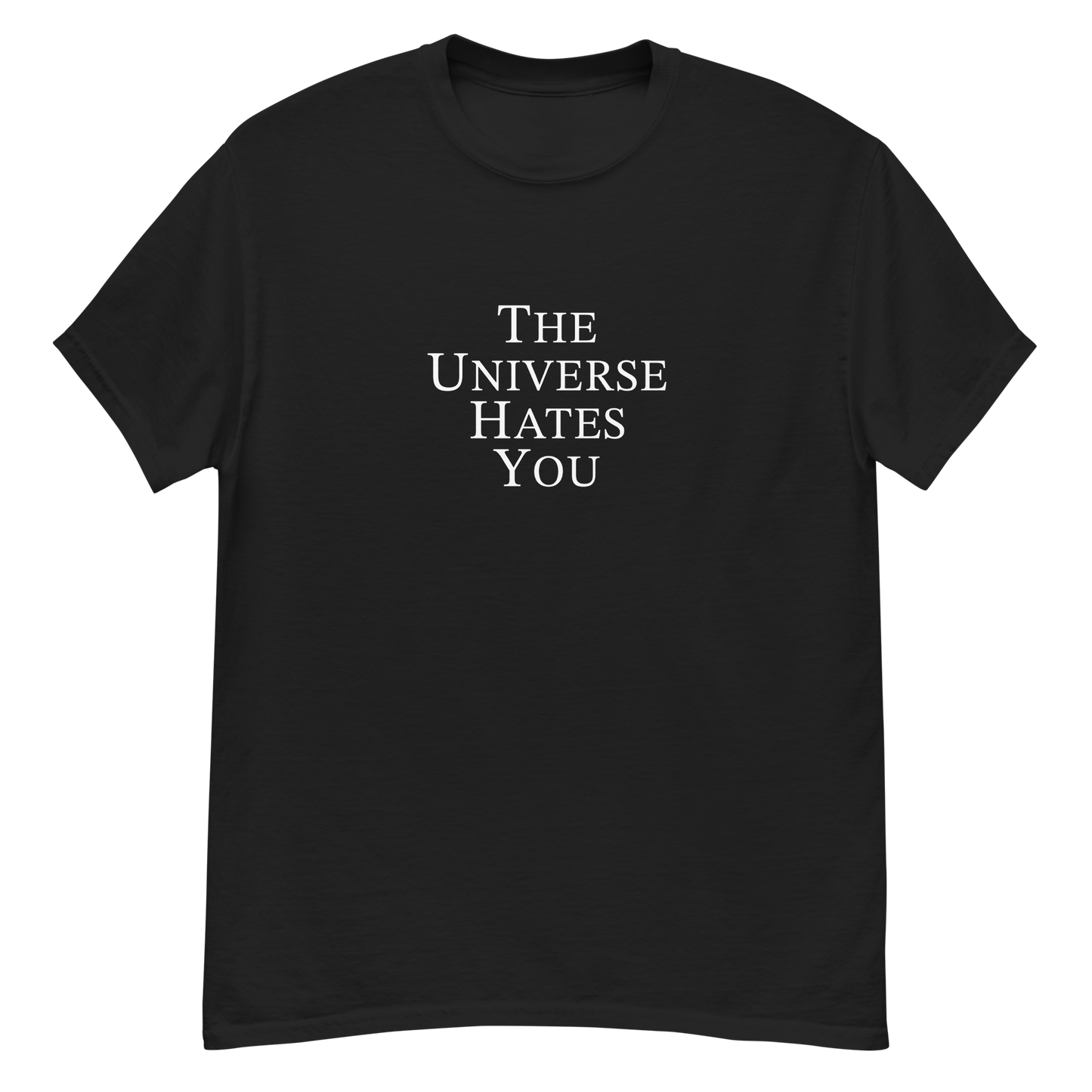 "The Universe Hates You" printed on a black unisex classic tee laying on a flat surface